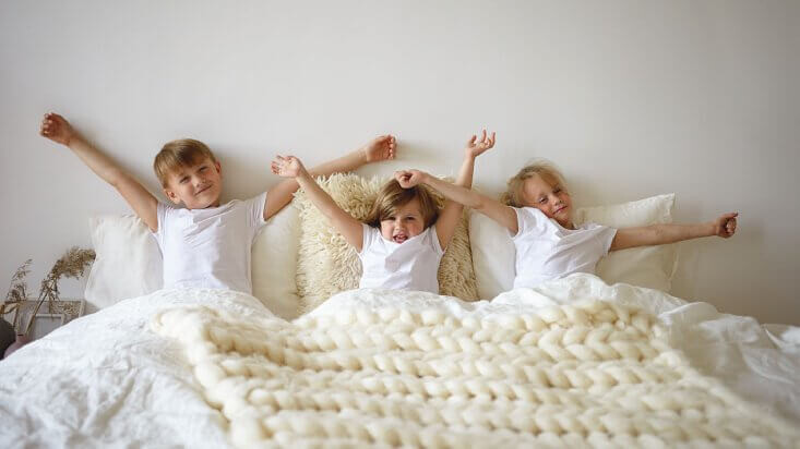 Trójka dzieci w łóżku z materacem Magniflex