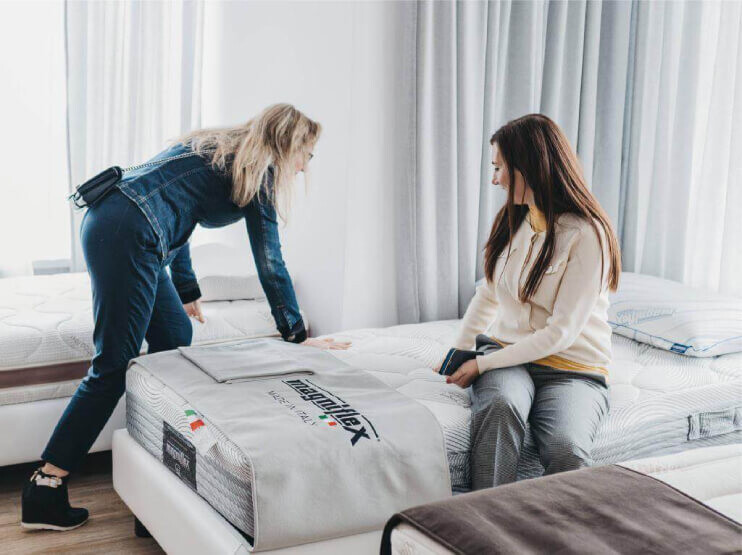 Kobiety testujące miękkie materace Magniflex w salonie