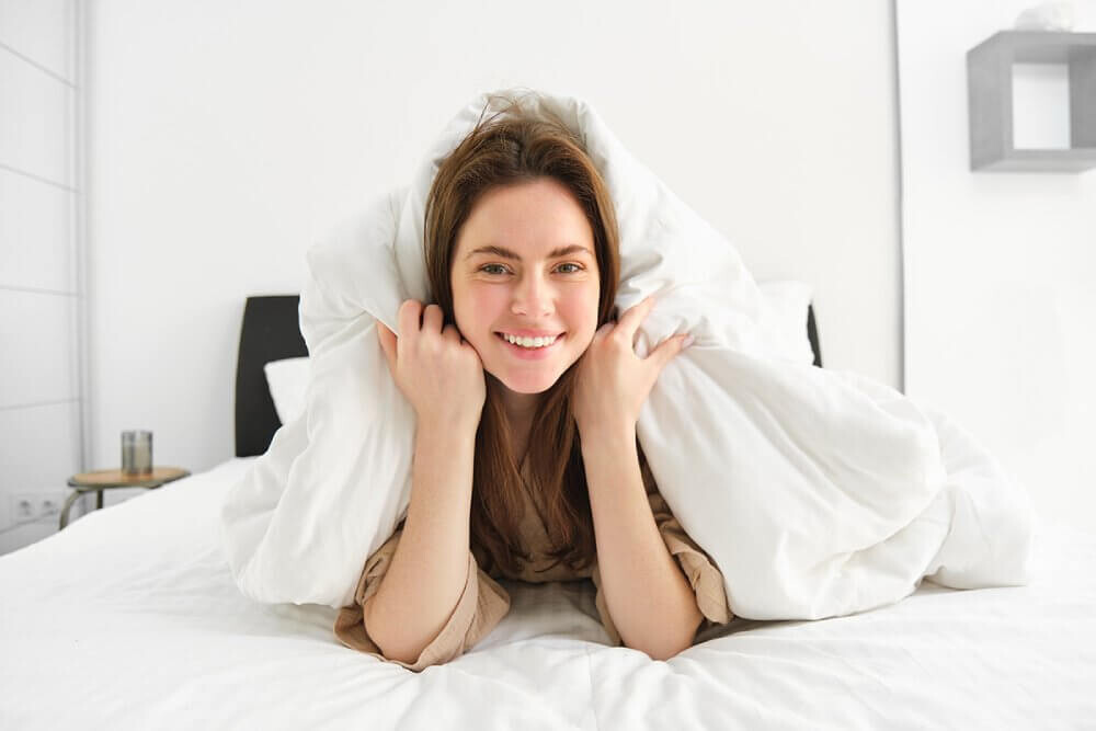 Uśmiechnięta kobieta po śnie na dobrym materacu