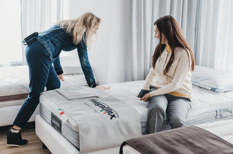 Kobiety testujące czy materac jest zbyt twardy