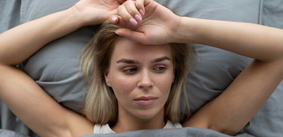 Kobieta leżąca w łóżku po niezbyt dobrze przespanej nocy spowodowanej złą wilgotnością powietrza