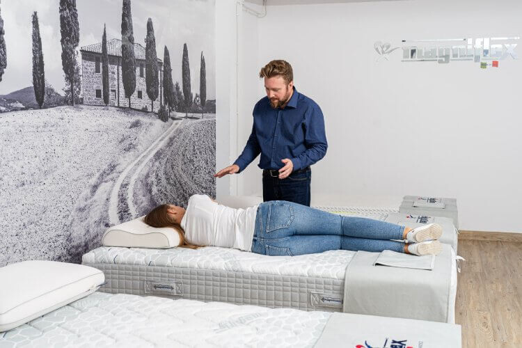 Kobieta testująca materac Magniflex w salonie